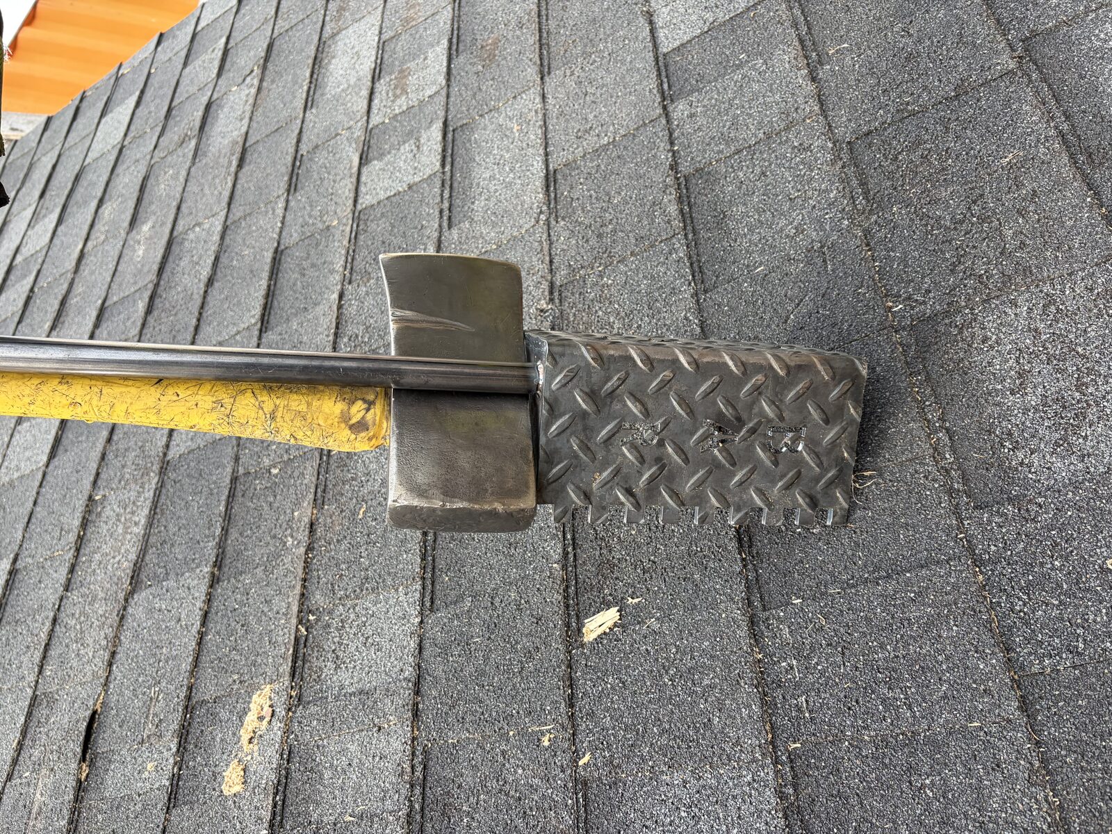 Rash Bar shown on roof next to a flathead axe demonstrating multi-tool use on the fireground