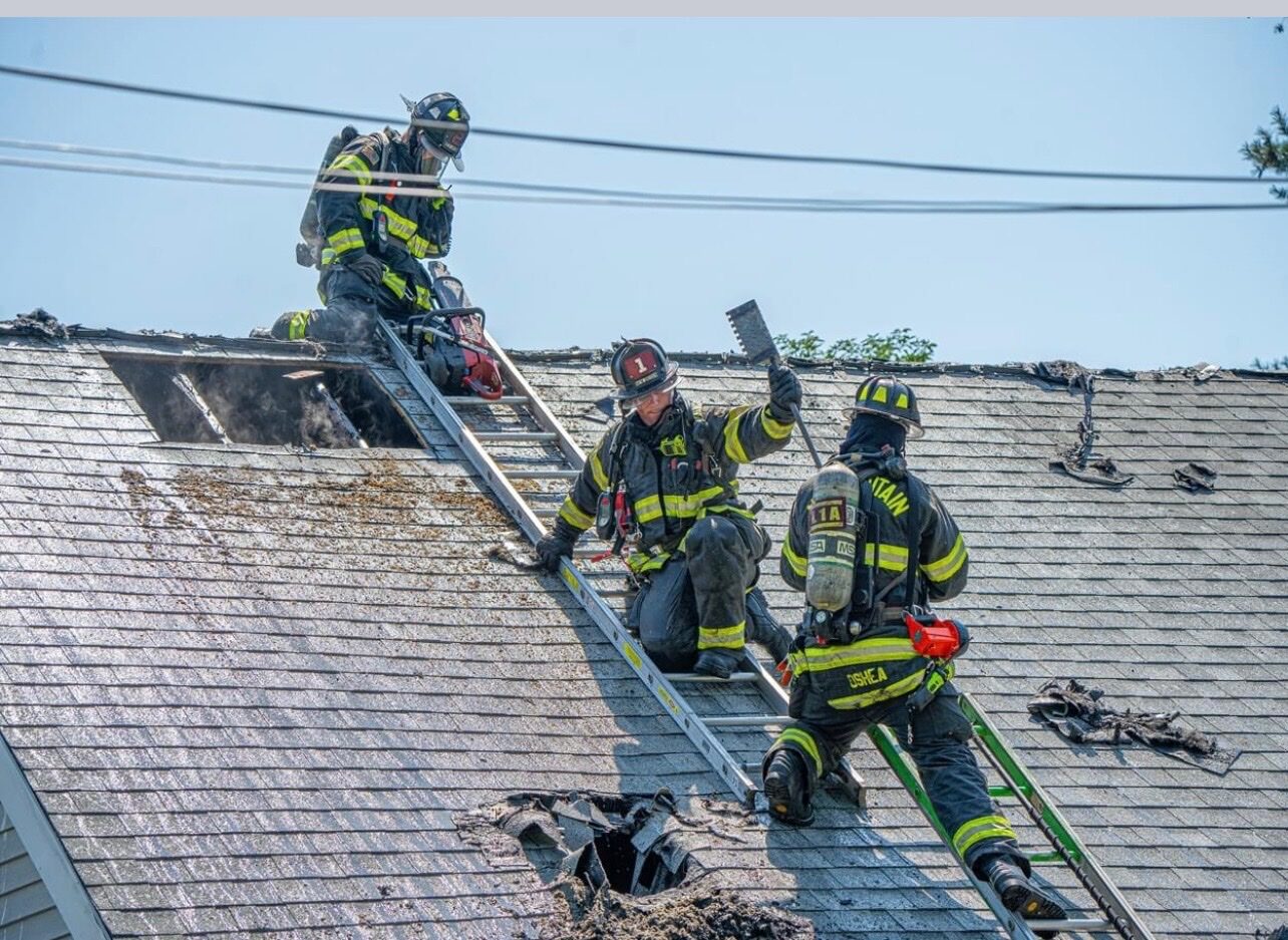 Three firefighters performing vertical ventilation at an actual fire using the Rash Bar